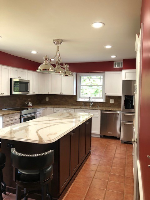 Example of a mid-sized transitional u-shaped terra-cotta tile and red floor eat-in kitchen design in Baltimore with an undermount sink, flat-panel cabinets, brown cabinets, quartz countertops, red backsplash, porcelain backsplash, stainless steel appliances, an island and white countertops