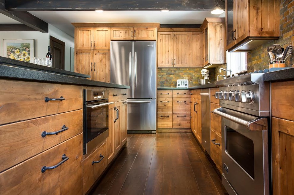 Design ideas for a mid-sized country u-shaped open plan kitchen in San Luis Obispo with an undermount sink, flat-panel cabinets, distressed cabinets, granite benchtops, multi-coloured splashback, stone tile splashback, stainless steel appliances, dark hardwood floors and with island.