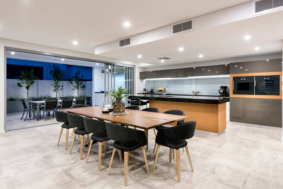 Photo of a large contemporary galley open plan kitchen in Perth with an undermount sink, flat-panel cabinets, medium wood cabinets, quartz benchtops, grey splashback, glass sheet splashback, black appliances, porcelain floors and with island.
