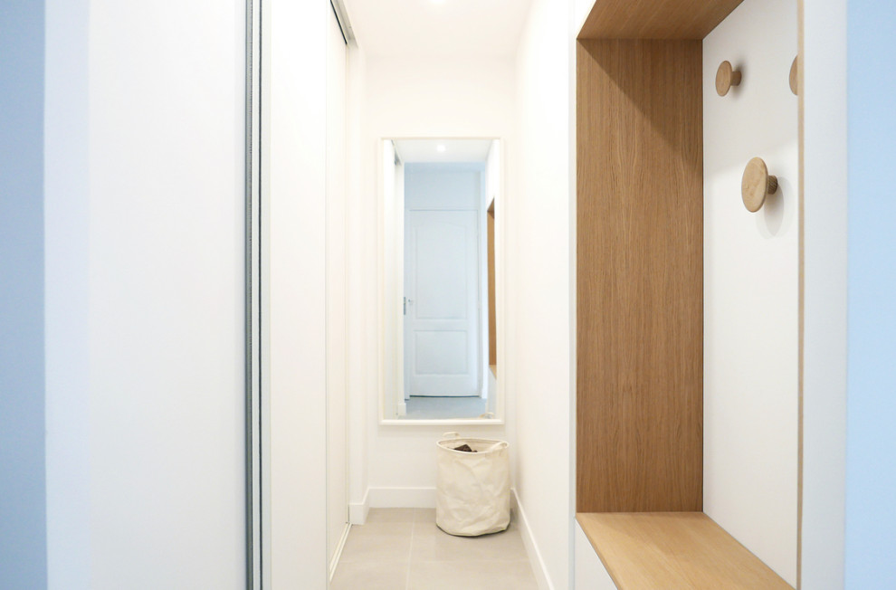 Exemple d'une grande armoire encastrée tendance en bois clair avec un placard à porte affleurante, sol en béton ciré, un sol gris et un plafond décaissé.