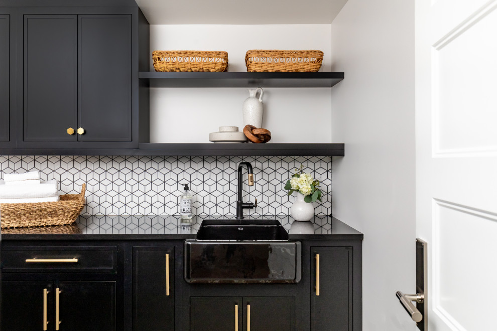Photo of a mid-sized transitional galley dedicated laundry room in Salt Lake City with a farmhouse sink, flat-panel cabinets, black cabinets, quartzite benchtops, white splashback, ceramic splashback, terra-cotta floors, a side-by-side washer and dryer, green floor, black benchtop and coffered.