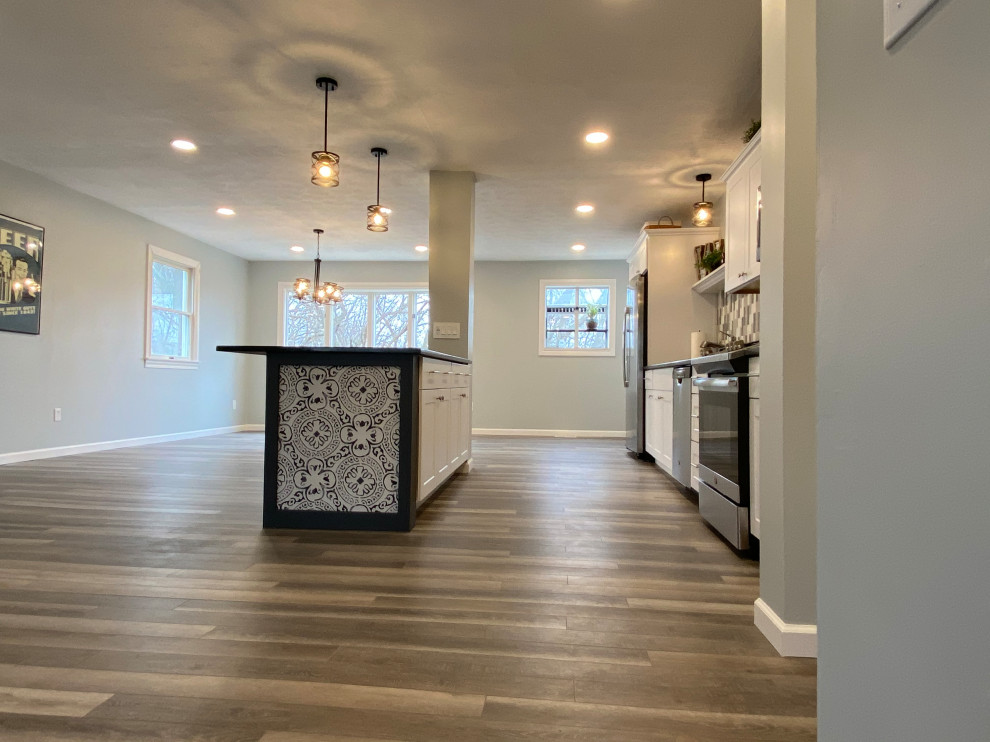 Inspiration for a large transitional l-shaped vinyl floor and gray floor open concept kitchen remodel in Cincinnati with an undermount sink, raised-panel cabinets, white cabinets, granite countertops, multicolored backsplash, ceramic backsplash, stainless steel appliances, an island and black countertops