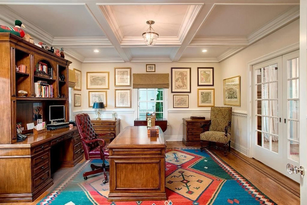 Study room - large traditional freestanding desk medium tone wood floor and brown floor study room idea with beige walls and no fireplace