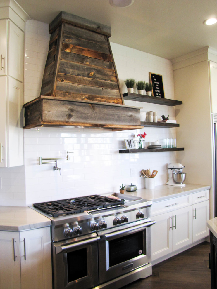 Kitchen - large transitional porcelain tile and brown floor kitchen idea in Phoenix with a farmhouse sink, white backsplash, subway tile backsplash, stainless steel appliances and an island