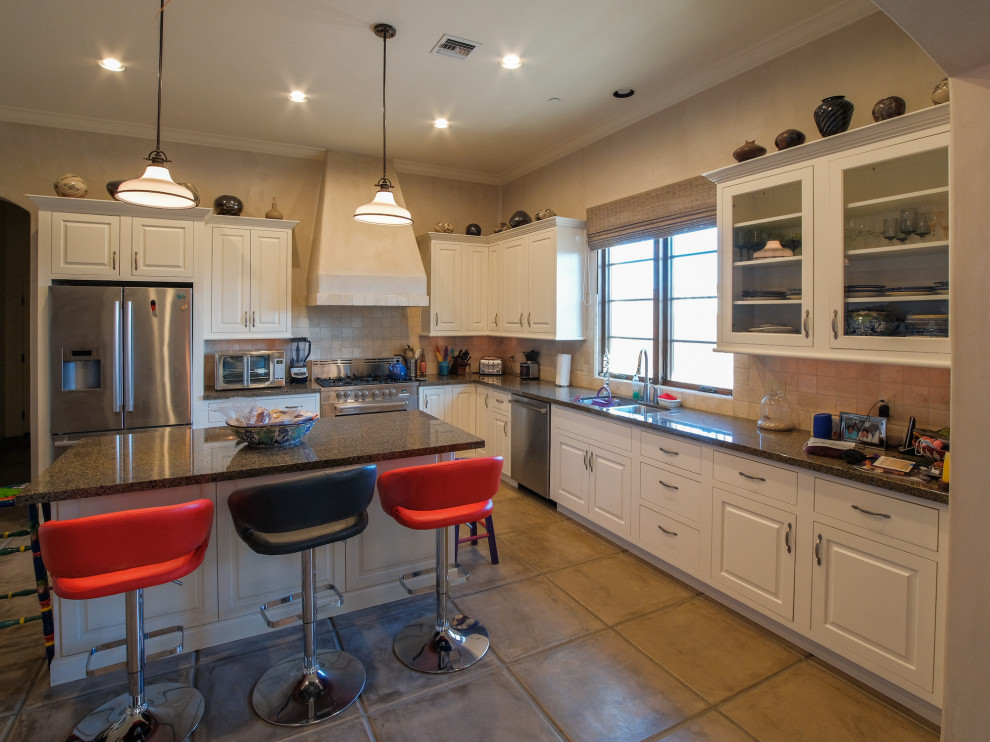 Exempel på ett stort amerikanskt kök, med en undermonterad diskho, luckor med upphöjd panel, vita skåp, granitbänkskiva, beige stänkskydd, stänkskydd i porslinskakel, cementgolv, en köksö och beiget golv