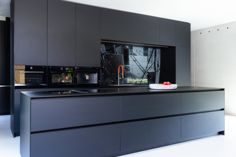Foto på ett mycket stort funkis svart kök, med släta luckor, svarta skåp, laminatbänkskiva, glaspanel som stänkskydd, svarta vitvaror och en köksö
