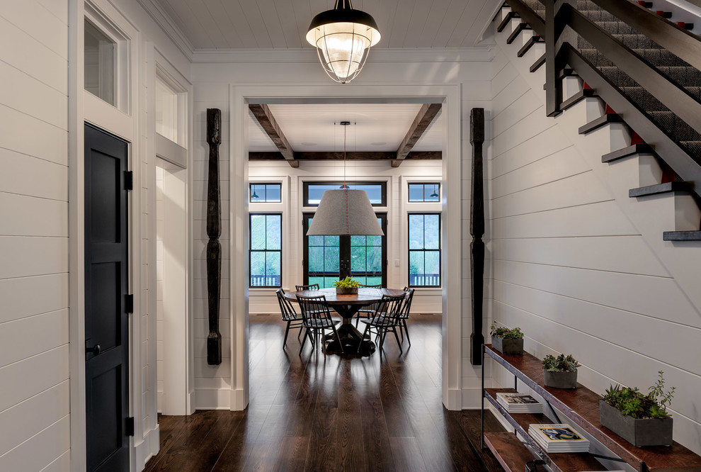 Design ideas for a large country hallway in New York with white walls, dark hardwood floors and brown floor.