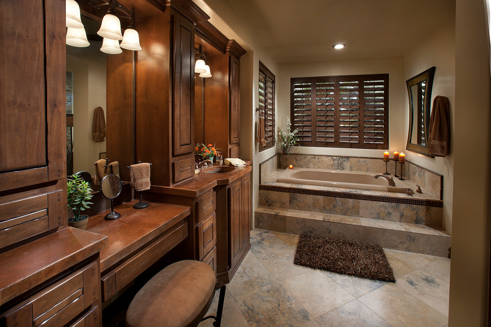 Inspiration for a mid-sized country master bathroom in Phoenix with an integrated sink, furniture-like cabinets, medium wood cabinets, granite benchtops, an alcove tub, beige tile, stone tile, beige walls and slate floors.
