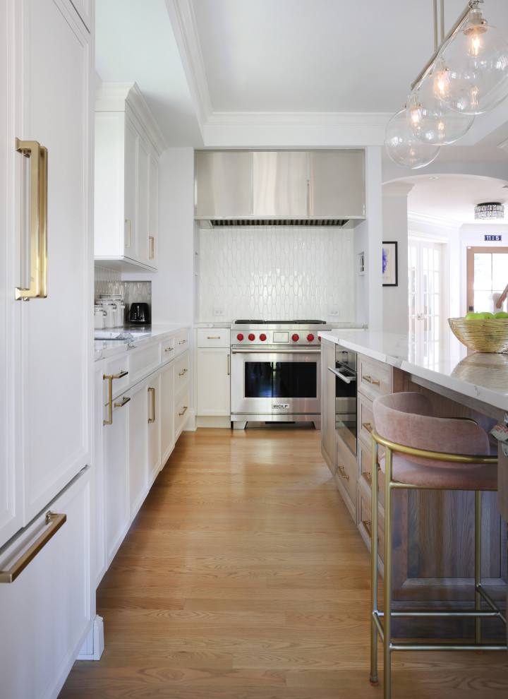 Eat-in kitchen - large transitional u-shaped light wood floor and tray ceiling eat-in kitchen idea in Chicago with a single-bowl sink, flat-panel cabinets, white cabinets, quartz countertops, white backsplash, glass tile backsplash, paneled appliances, an island and white countertops