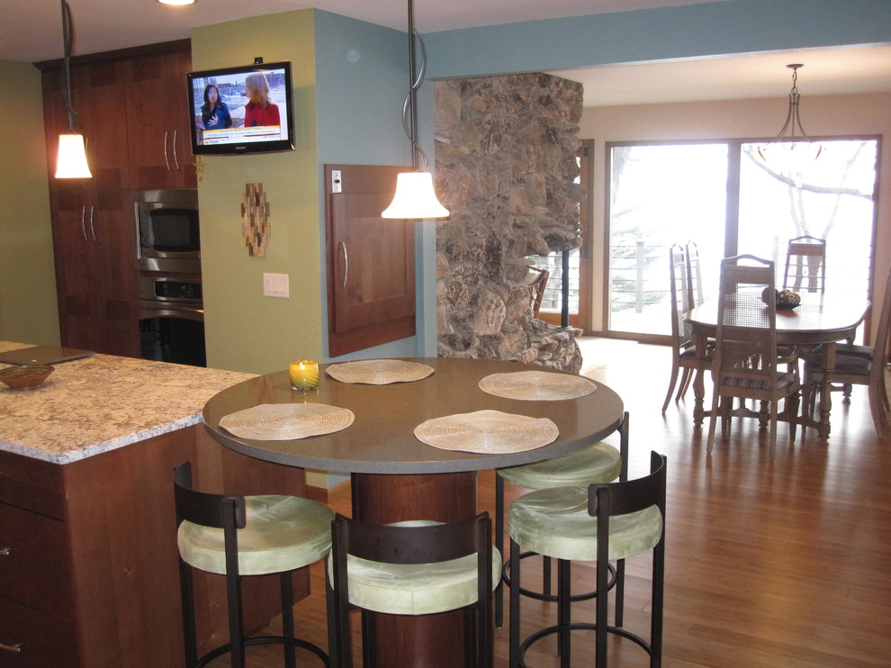 Contemporary l-shaped eat-in kitchen in Milwaukee with an undermount sink, recessed-panel cabinets, medium wood cabinets, granite benchtops, stainless steel appliances, bamboo floors and with island.