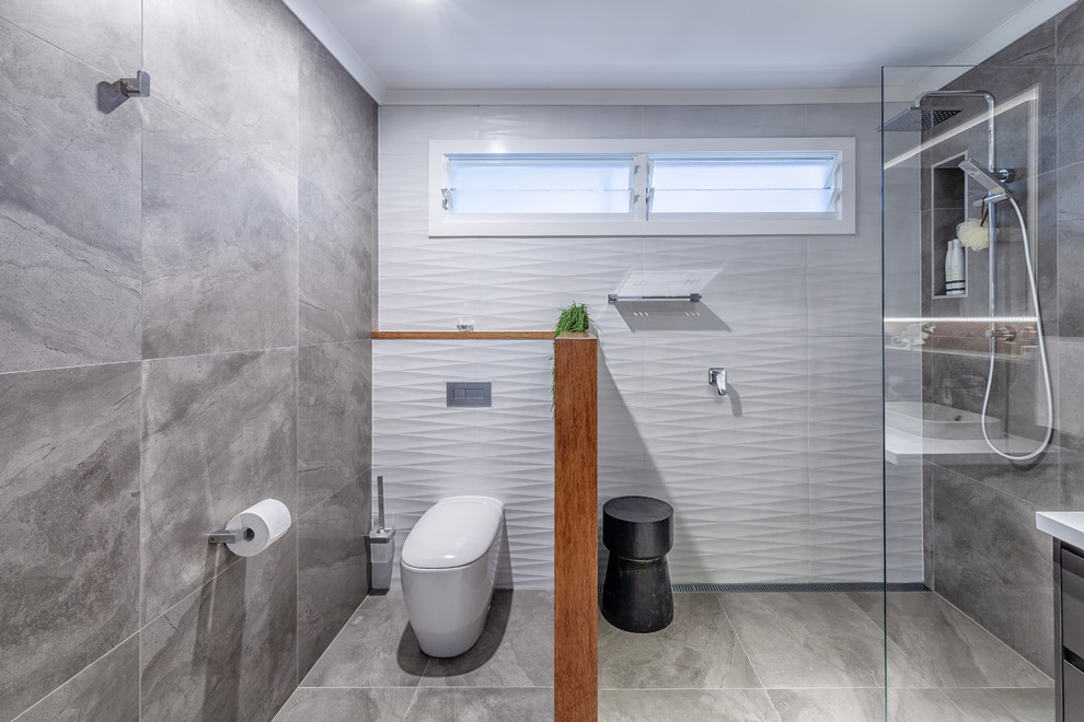 Photo of a contemporary 3/4 wet room bathroom in Brisbane with flat-panel cabinets, black cabinets, a one-piece toilet, gray tile, grey walls, grey floor, an open shower and white benchtops.