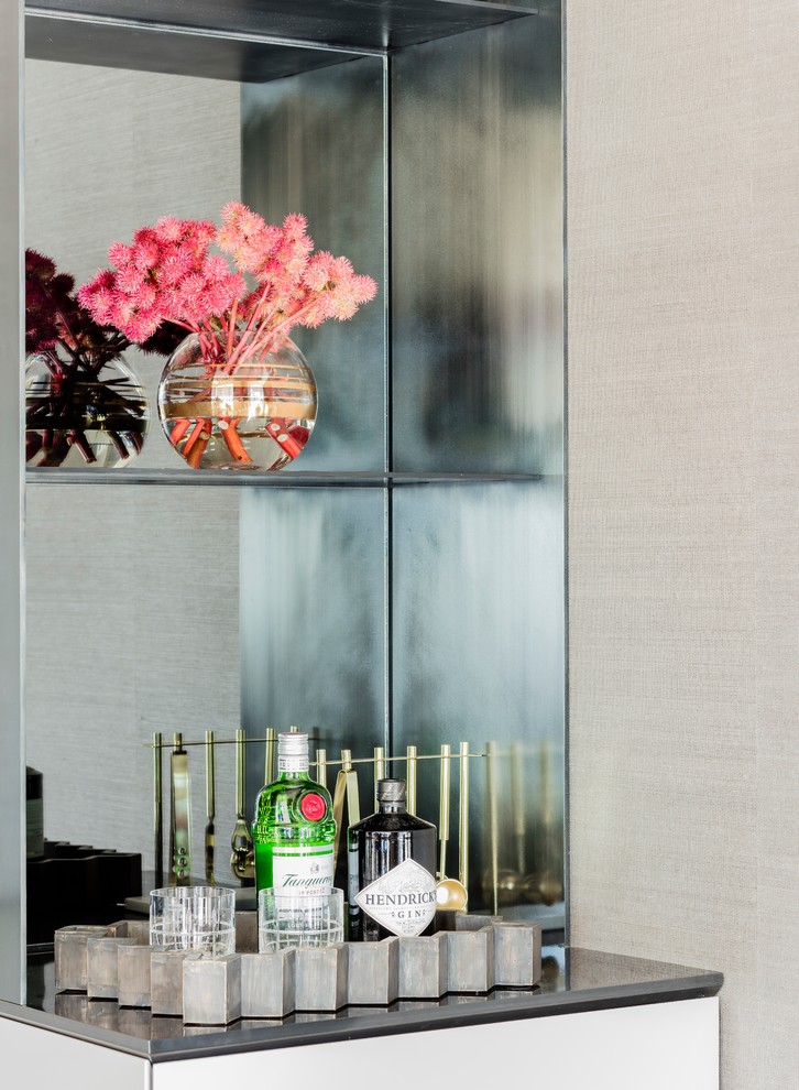 Mid-sized trendy medium tone wood floor and brown floor eat-in kitchen photo in Boston with flat-panel cabinets, gray cabinets, stainless steel countertops, mirror backsplash, an island, an undermount sink and stainless steel appliances