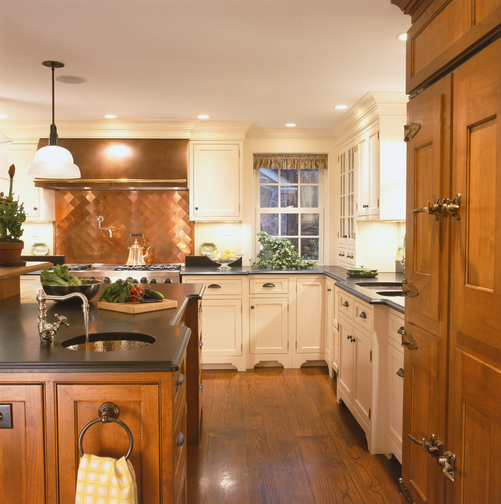 This is an example of a large country u-shaped eat-in kitchen in Other with shaker cabinets, medium wood cabinets, soapstone benchtops, stainless steel appliances, medium hardwood floors, with island, an undermount sink, metallic splashback and metal splashback.