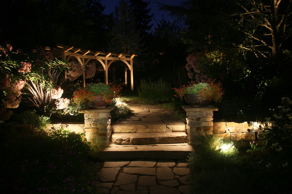 Photo of a large traditional backyard partial sun garden in Portland with a retaining wall and natural stone pavers.