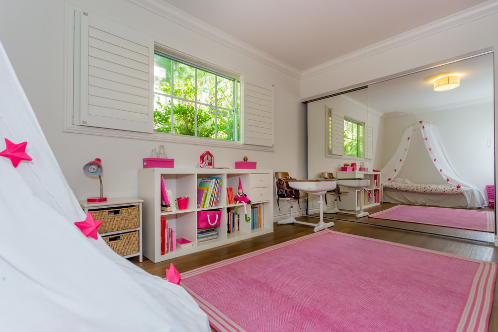 Design ideas for a mid-sized transitional kids' room for girls in Los Angeles with white walls and medium hardwood floors.