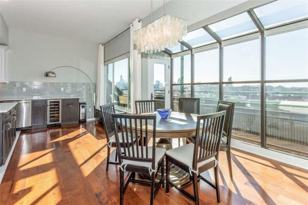 Inspiration for a medium sized traditional kitchen/dining room in New York with medium hardwood flooring, brown floors, a vaulted ceiling and grey walls.