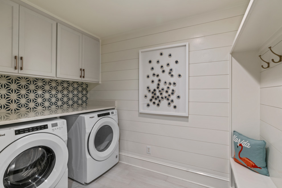 Inspiration for a mid-sized beach style laundry room in Other with white walls, medium hardwood floors and grey floor.