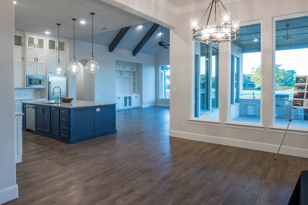 Large transitional u-shaped medium tone wood floor and brown floor eat-in kitchen photo in Dallas with a drop-in sink, recessed-panel cabinets, white cabinets, granite countertops, white backsplash, ceramic backsplash, stainless steel appliances, an island and gray countertops