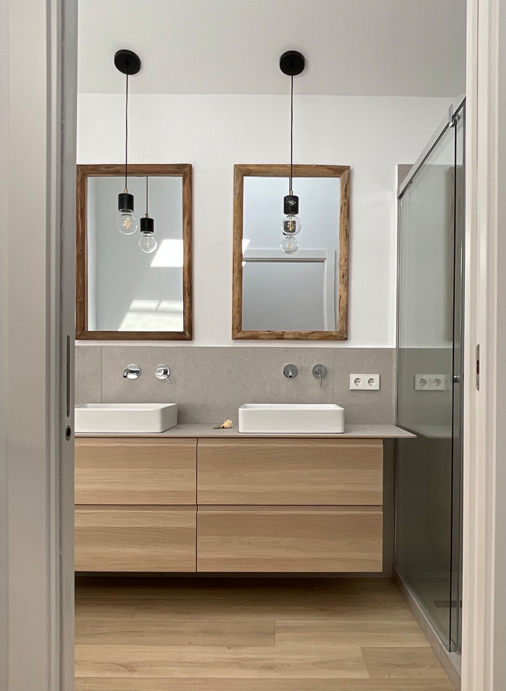 Inspiration for a mid-sized modern master gray tile laminate floor, brown floor and double-sink bathroom remodel in Barcelona with white cabinets, a wall-mount toilet, white walls, a vessel sink, tile countertops, gray countertops and a floating vanity
