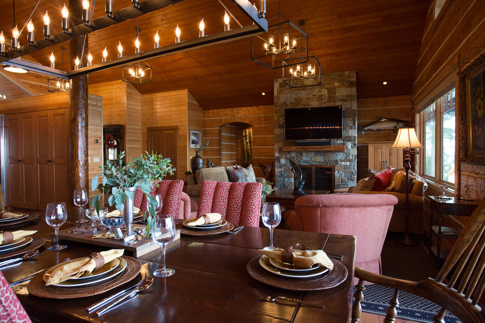 Large country open plan dining in Seattle with brown walls, medium hardwood floors, a standard fireplace, a stone fireplace surround and brown floor.