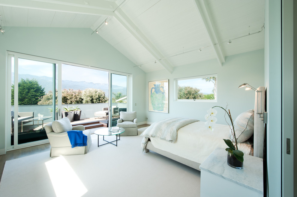This is an example of a large beach style master bedroom in Santa Barbara with grey walls, medium hardwood floors, no fireplace and brown floor.