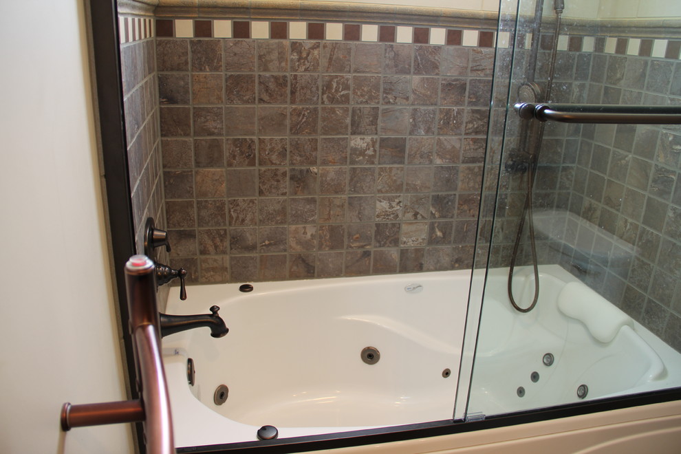 Transitional brown tile and porcelain tile porcelain tile tub/shower combo photo in Columbus with a vessel sink, an undermount tub, a two-piece toilet, raised-panel cabinets, medium tone wood cabinets, granite countertops and beige walls