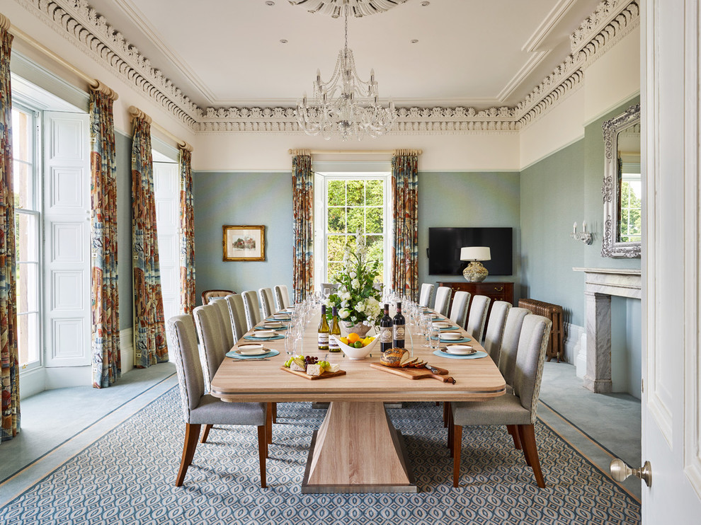 Inspiration for a large traditional separate dining room in Other with blue walls, carpet and a stone fireplace surround.