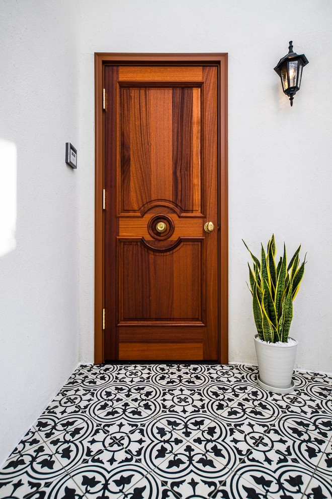 This is an example of a transitional front door in Other with white walls, porcelain floors, a single front door and a dark wood front door.