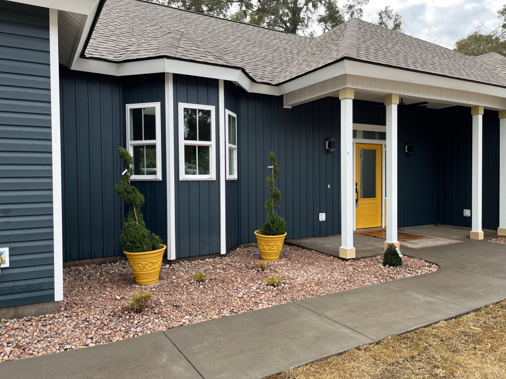 Mittelgroßes, Einstöckiges Maritimes Einfamilienhaus mit Vinylfassade, blauer Fassadenfarbe, Walmdach, Schindeldach und schwarzem Dach in Charleston