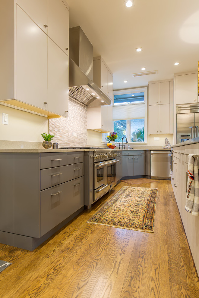 Inspiration for a mid-sized modern galley eat-in kitchen in Austin with an undermount sink, flat-panel cabinets, grey cabinets, soapstone benchtops, multi-coloured splashback, mosaic tile splashback, stainless steel appliances, light hardwood floors and with island.