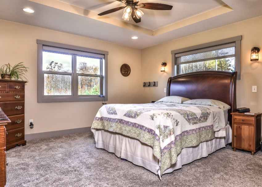 Immagine di una camera matrimoniale country con pareti beige, moquette, pavimento grigio e soffitto ribassato