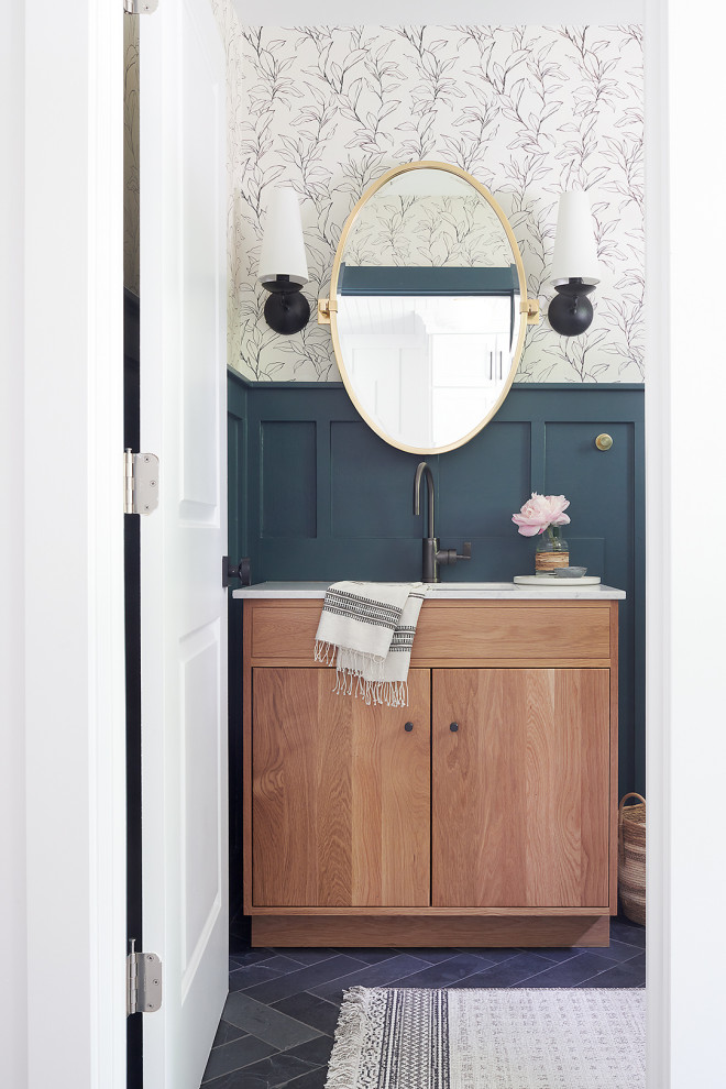 This is an example of a small country cloakroom in Philadelphia with flat-panel cabinets, light wood cabinets, green walls, slate flooring, grey floors and wainscoting.