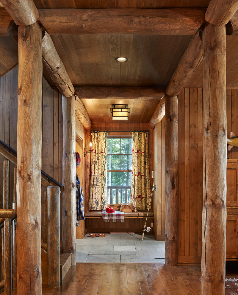 This is an example of a country entryway in Minneapolis with brown walls, dark hardwood floors and brown floor.