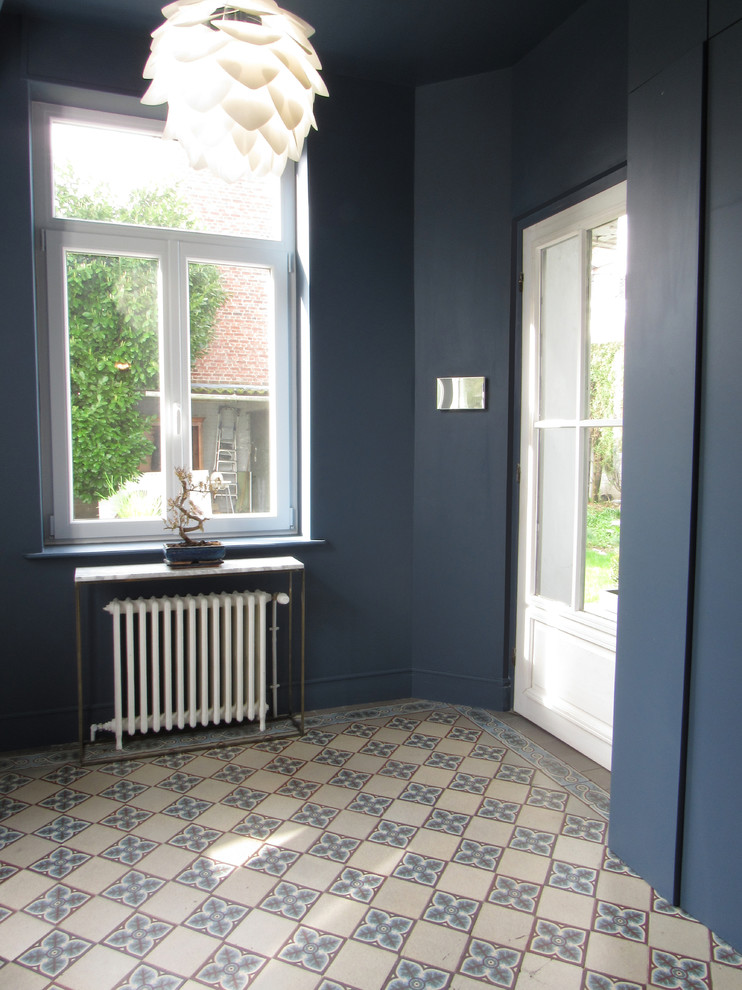 Large midcentury foyer in Lille with blue walls, ceramic floors, a single front door and a white front door.
