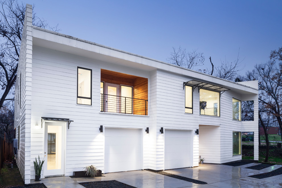 This is an example of a modern two-storey white duplex exterior in Austin with wood siding and clapboard siding.