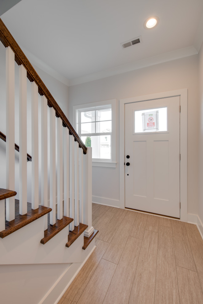 Inspiration for a mid-sized transitional vinyl floor and brown floor front door remodel with gray walls and a white front door