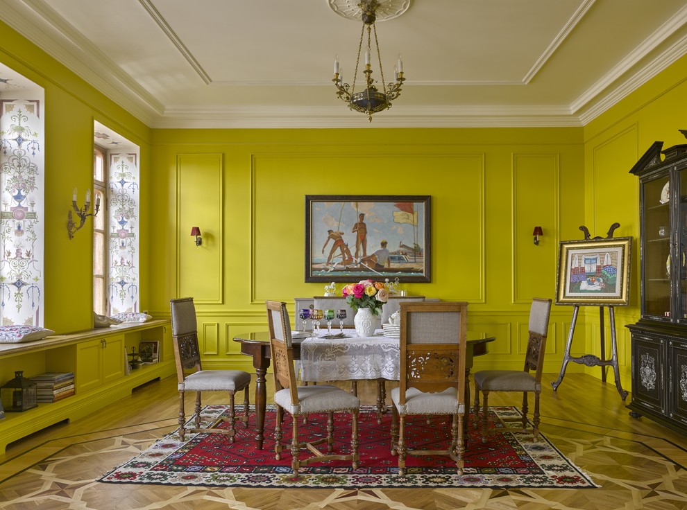 Design ideas for an eclectic dining room in Moscow with yellow walls and light hardwood floors.