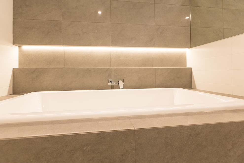 Inspiration for a mid-sized contemporary bathroom in Brisbane with a drop-in tub, an open shower, gray tile, ceramic tile, white walls, porcelain floors, an undermount sink, engineered quartz benchtops, grey floor and an open shower.