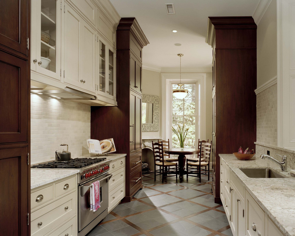 Photo of a traditional galley eat-in kitchen in Philadelphia with panelled appliances, beaded inset cabinets, beige cabinets, an undermount sink, beige splashback and limestone splashback.