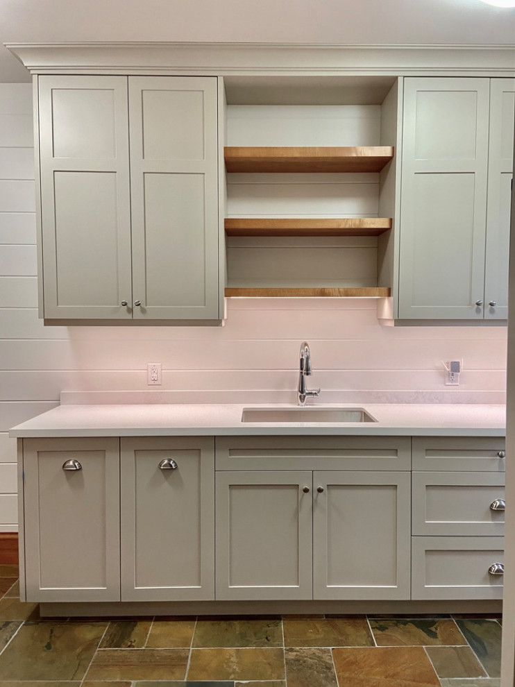 Inspiration for a mid-sized transitional galley utility room in Toronto with an undermount sink, shaker cabinets, grey cabinets, quartz benchtops, white splashback, engineered quartz splashback, white walls, slate floors, a side-by-side washer and dryer, multi-coloured floor, white benchtop and planked wall panelling.