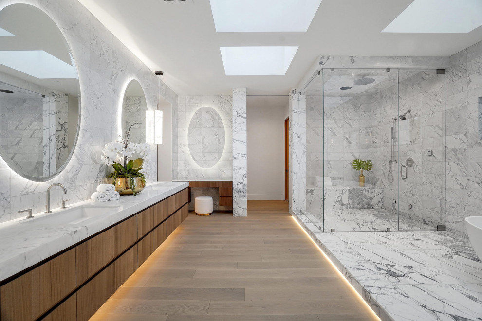 Large contemporary ensuite bathroom in Los Angeles with flat-panel cabinets, brown cabinets, a freestanding bath, a built-in shower, white tiles, porcelain tiles, white walls, marble flooring, a submerged sink, solid surface worktops, white floors, a hinged door, white worktops, double sinks, a floating vanity unit and a coffered ceiling.