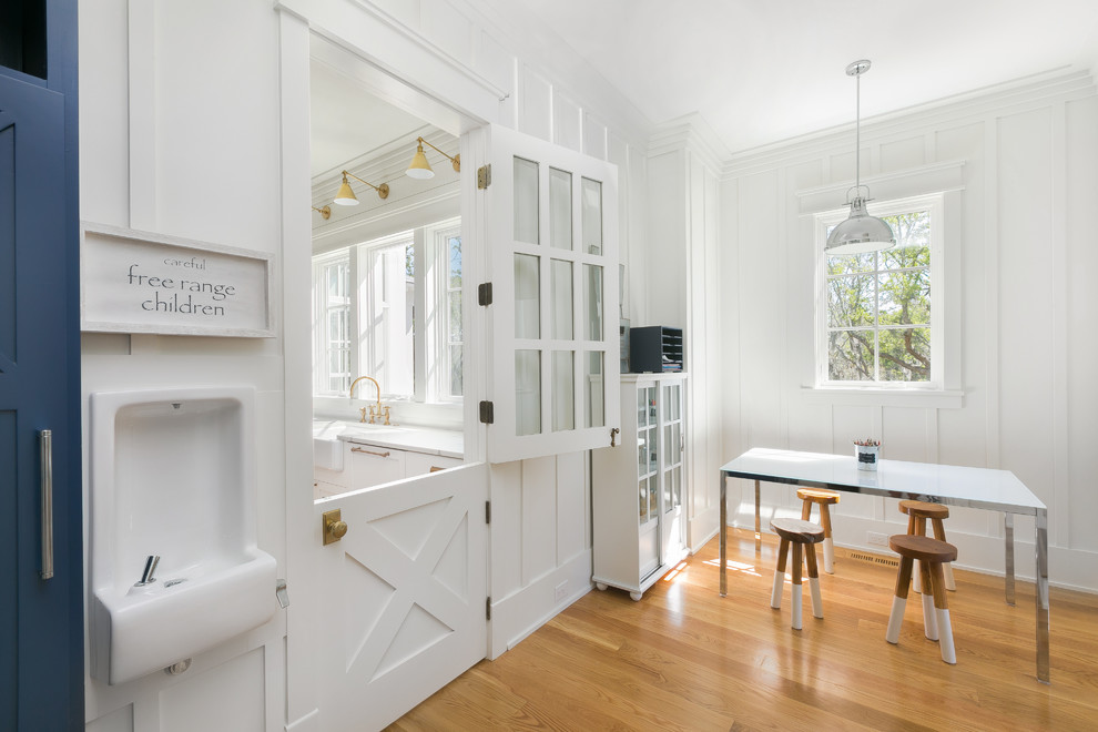 Beach style gender-neutral medium tone wood floor and brown floor playroom photo in Charleston with white walls