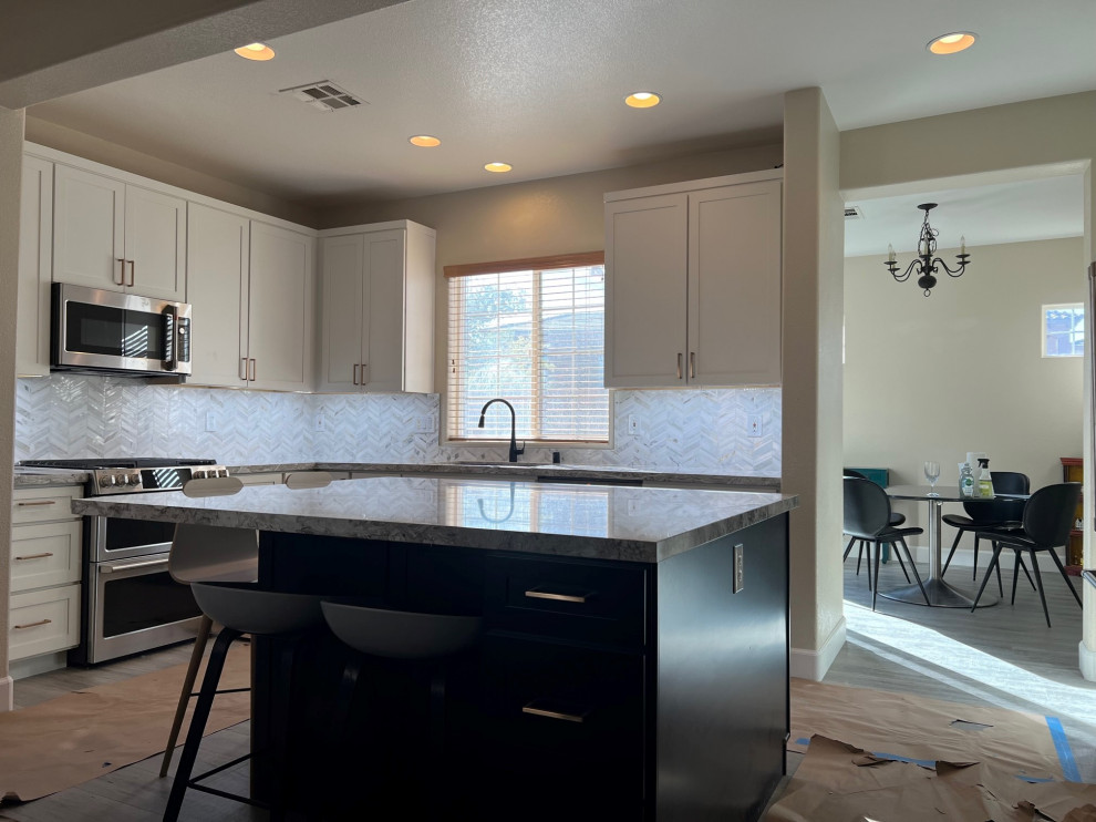 Mid-sized transitional l-shaped kitchen photo in Las Vegas with shaker cabinets, white cabinets, quartz countertops, stainless steel appliances and an island