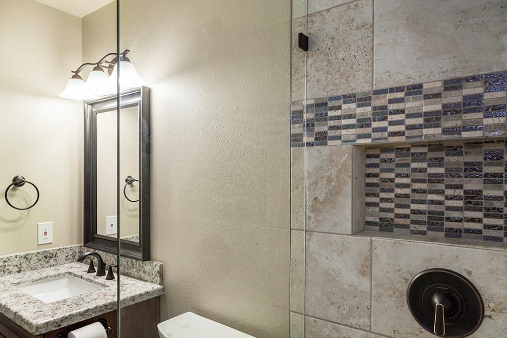 Mid-sized transitional kids' beige tile and porcelain tile porcelain tile and beige floor alcove shower photo in Phoenix with shaker cabinets, dark wood cabinets, a two-piece toilet, beige walls, an undermount sink, granite countertops and a hinged shower door
