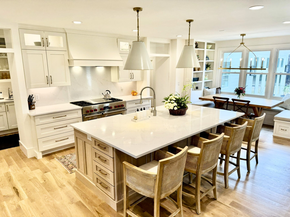 Eat-in kitchen - mid-sized transitional l-shaped light wood floor, brown floor and wallpaper ceiling eat-in kitchen idea in Atlanta with a farmhouse sink, shaker cabinets, white cabinets, granite countertops, white backsplash, stainless steel appliances, an island and white countertops
