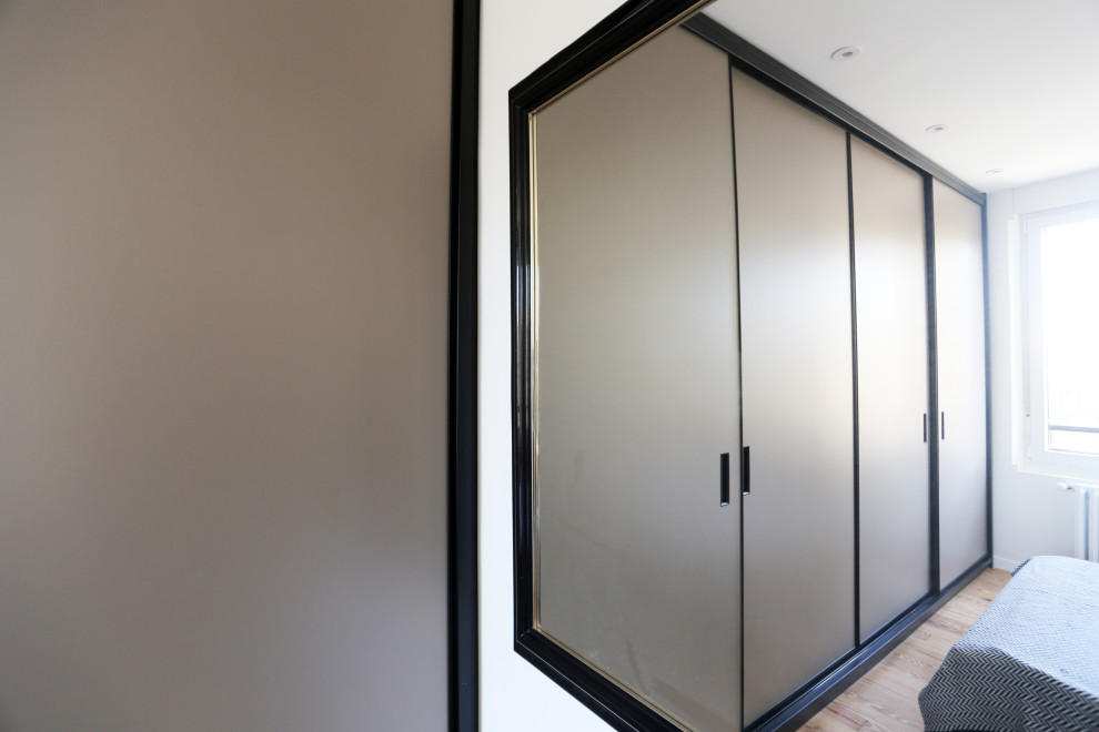 Exemple d'une armoire encastrée industrielle de taille moyenne avec un sol en bois brun, un sol marron et un placard à porte plane.
