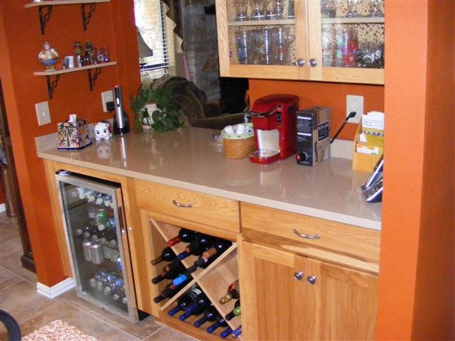 Inspiration for a mid-sized country galley wet bar in Austin with raised-panel cabinets, light wood cabinets, laminate benchtops and ceramic floors.