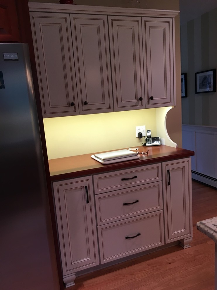 Eat-in kitchen - transitional u-shaped light wood floor eat-in kitchen idea in Boston with an undermount sink, raised-panel cabinets, granite countertops, subway tile backsplash, stainless steel appliances and an island