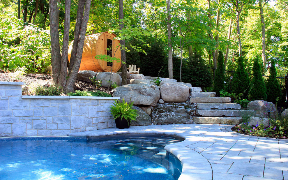 Mid-sized elegant backyard concrete paver and custom-shaped pool fountain photo in Montreal