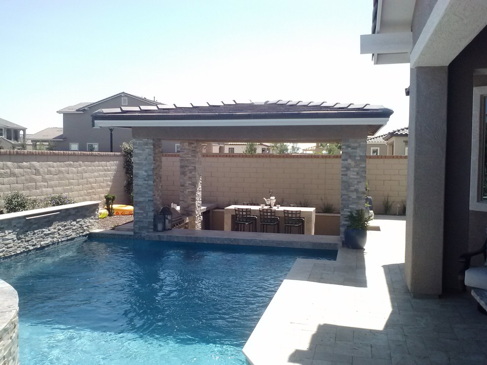 Inspiration for a mid-sized mediterranean backyard custom-shaped pool in Phoenix with tile and a pool house.